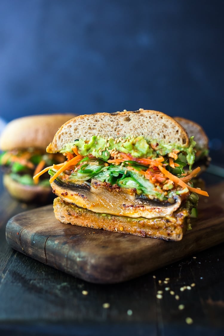 portobello mushroom burger sliced in half- juicy grilled portobello with cucumber salad, carrot slaw, and Asian guacamole.