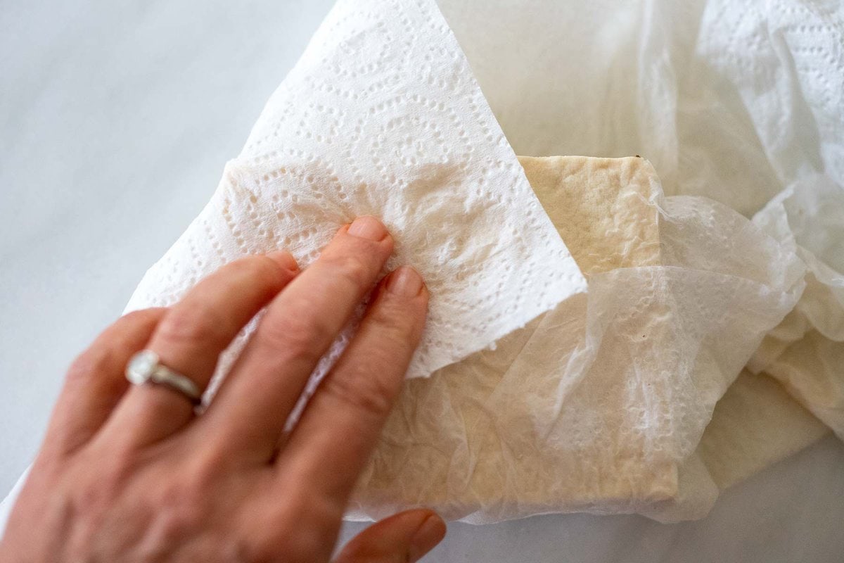 blotting the tofu with paper towels.