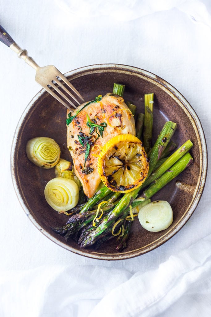 tarragon chicken served with roasted asparagus, leeks, and lemon.