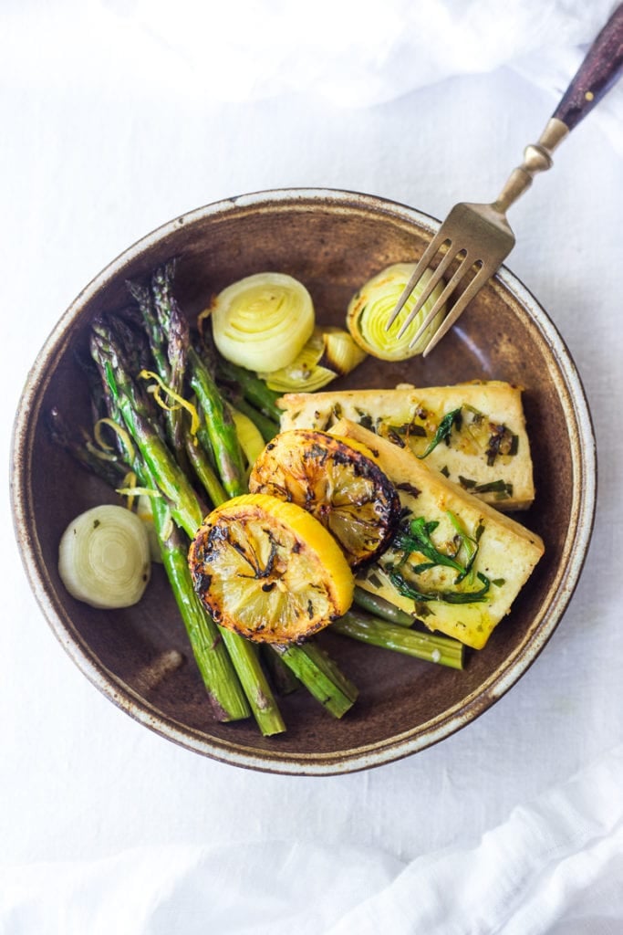 example of plate with tarragon tofu served with roasted asparagus, lemon and leeks.