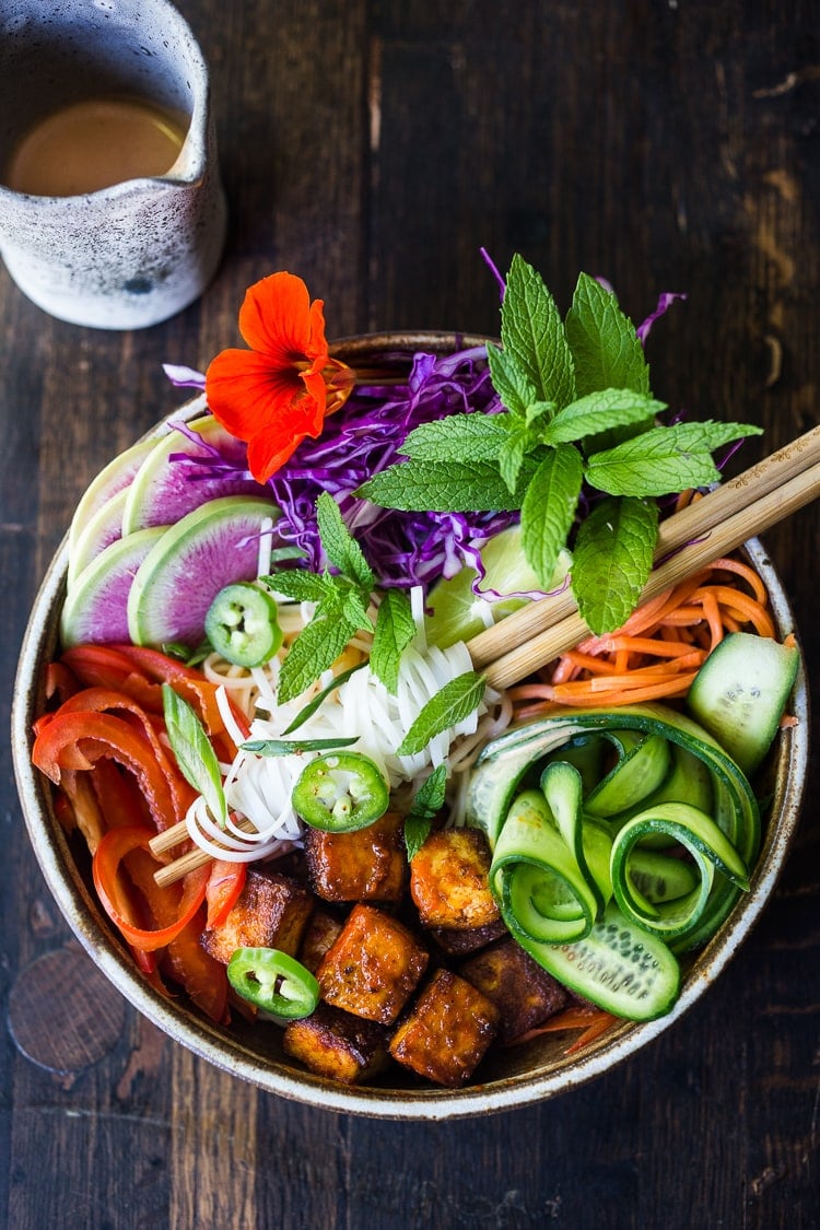 Fresh and delicious Vegan Bahn Mi Noodle Bowl with Sriracha Tofu, rice noodles, pickled carrots and radishes, crunchy cucumber and cabbage and a creamy vegan spicy Bahn Mi dressing! #bahnmi #healthybowl #noodlebowl #vegan #veganbowl #bahnmibowl #noodles