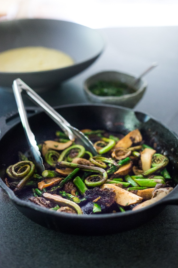 Creamy Polenta with Spring Veggies and Gremolata - a simple healthy VEGAN recipe featuring vibrant spring produce that can be made in under 30 minutes. Vegan & Gluten Free! #creamypolenta #vegan #springrecipes #asparagus #fiddleheadferns #morel #porcini #softpolenta #veganpolenta 