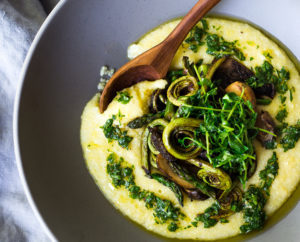 A simple elegant recipe for Creamy Polenta with Spring Veggies and Gremolata -  flavorful and healthy featuring vibrant spring produce that can be made in under 30 minutes. Vegan & Gluten Free! #creamypolenta #vegan #springrecipes #asparagus #fiddleheadferns #morel #porcini #softpolenta #veganpolenta