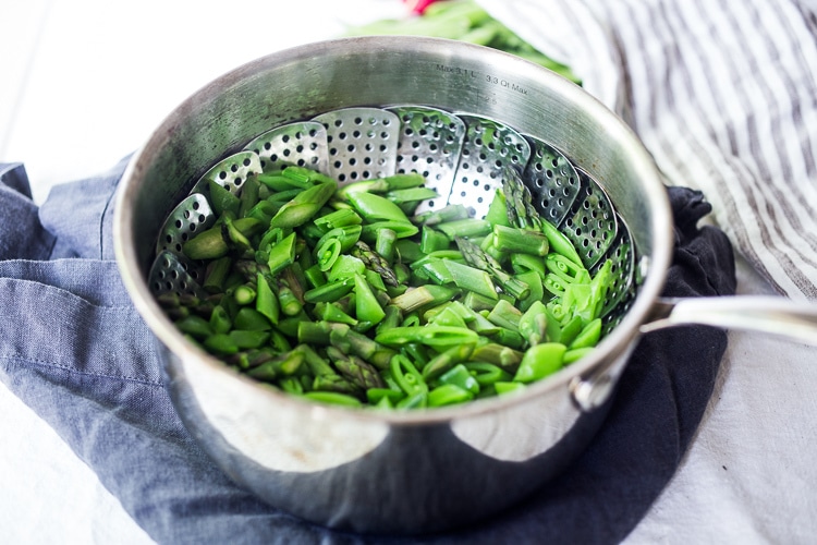 pot with colander, blanching fresh green spring veggies.