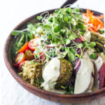 These Mediterranean Falafel Bowls are the best! Made your choice of grain, lots of healthy veggies and drizzled with tahini sauce- the falafels can be prepped ahead for the busy workweek. Vegan and Gluten-free! 
