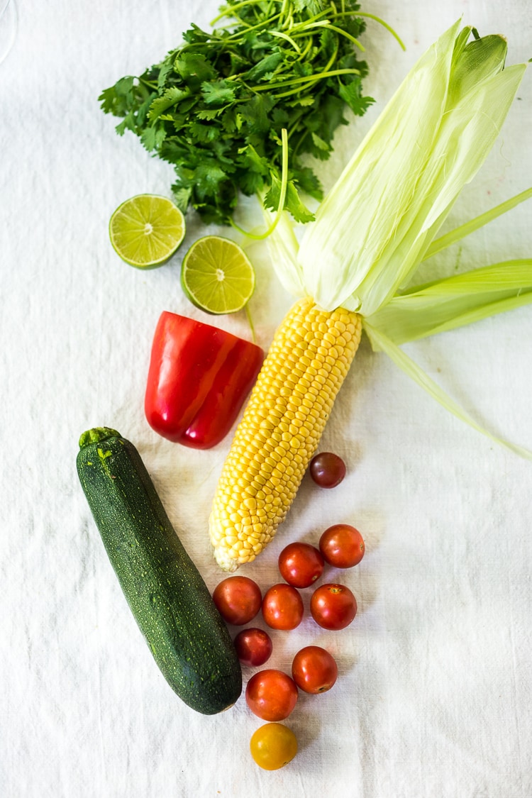 This Corn and Zucchini Pasta Salad is made with gluten-free rice noodles and loaded up with grilled summer veggies, then tossed in the most flavorful Cilantro Pesto.... deliciously addicting! Vegan and Gluten-free! #summerpastasalad #pastasalad #cornpasta #cilantropesto #zucchinipasta #zucchini #potluck