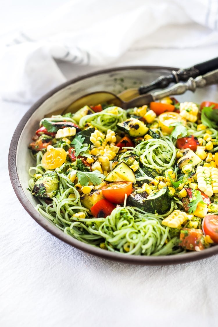 Summer Pasta Salad w/ Grilled Zucchini, Corn and Cilantro Pesto is made with gluten-free rice noodles and loaded up with healthy summer veggies, then tossed in the most flavorful Cilantro Pesto.... deliciously addicting and perfect for potluck meals!  Vegan and Gluten-free! #summerpastasalad #pastasalad #cornpasta #cilantropesto #zucchinipasta #zucchini #potluck