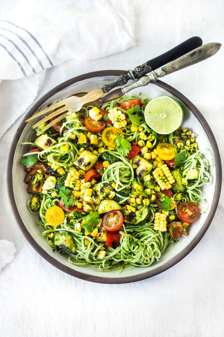 This Corn and Zucchini Pasta Salad is made with gluten-free rice noodles and loaded up with grilled summer veggies, then tossed in the most flavorful Cilantro Pesto.... deliciously addicting! Vegan and Gluten-free! #summerpastasalad #pastasalad #cornpasta #cilantropesto #zucchinipasta #zucchini #potluck