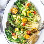 Healthy delicious, Grilled Romaine Salad with Corn, Fava Beans and Avocado - a light and refreshing summer meal. Keep it vegan or add grilled shrimp for added protein. Either way, it's sure to be your new favorite salad. Don't have access to fresh Fava beans? No worries, sub edamame! #grilledromaine #salad #romaine #fava #avocado #grilled #vegan