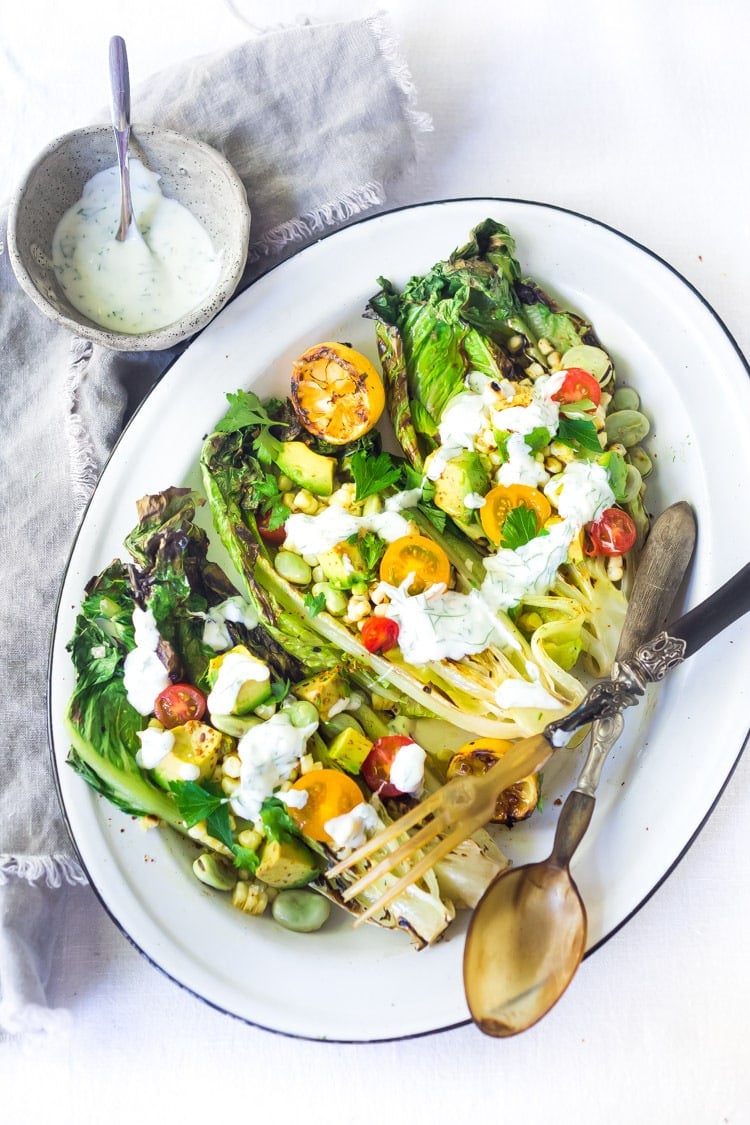 Healthy delicious, Grilled Romaine Salad with Corn, Fava Beans and Avocado - a light and refreshing summer meal. Keep it vegan or add grilled shrimp for added protein. Either way, it's sure to be your new favorite salad. Don't have access to fresh Fava beans? No worries, sub edamame! #grilledromaine #salad #romaine #fava #avocado #grilled #vegan