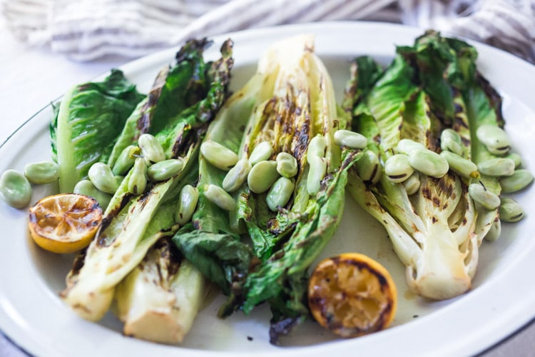 Healthy delicious, Grilled Romaine Salad with Corn, Fava Beans and Avocado - a light and refreshing summer meal. Keep it vegan or add grilled shrimp for added protein. Either way, it's sure to be your new favorite salad. Don't have access to fresh Fava beans? No worries, sub edamame! #grilledromaine #salad #romaine #fava #avocado #grilled #vegan 