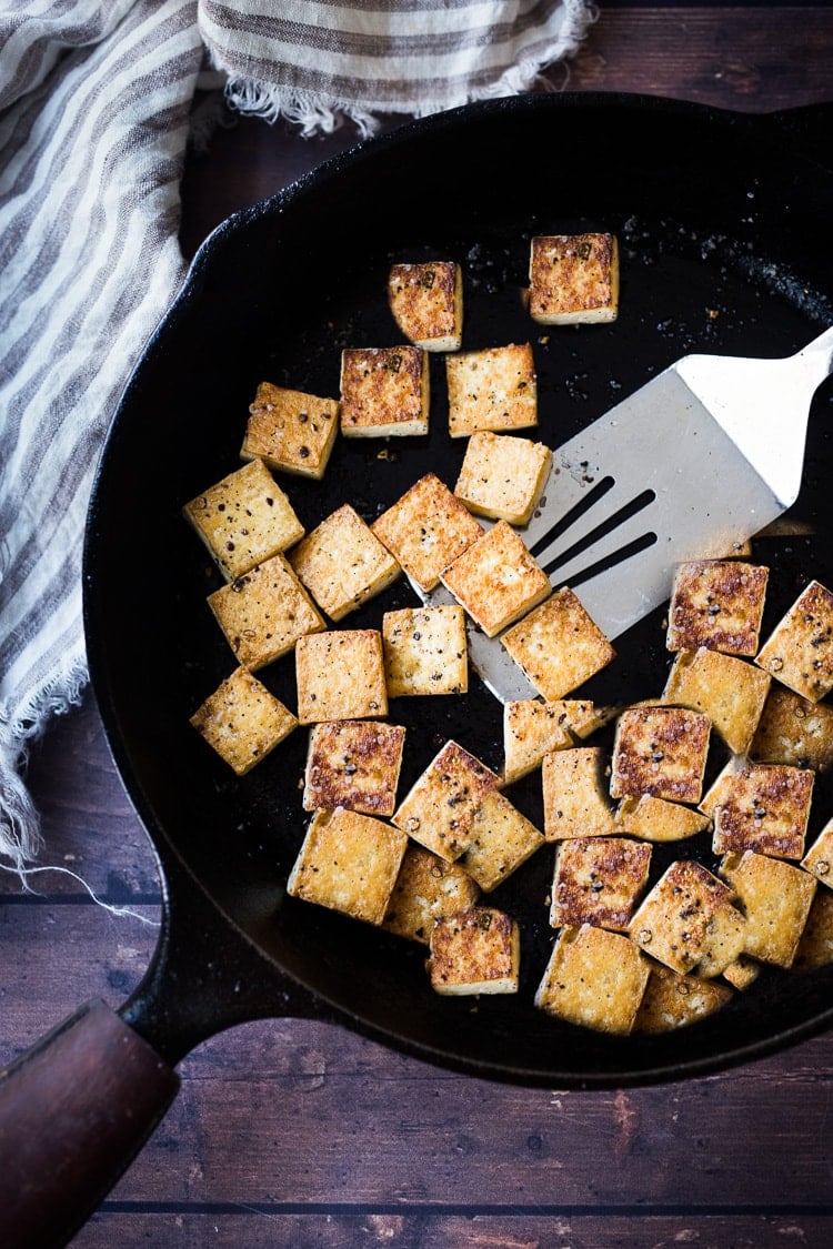 Here's a simple easy recipe for Crispy Tofu that can be made on the stovetop in 20 minutes with just 3 ingredients. You'll find a million uses for this crispy tofu and fun ways to season it - adding it to meals you are already making. #crispytofu #simpletofurecipes #easytofu #tofu #tofurecipes #friedtofu #stirfriedtofu