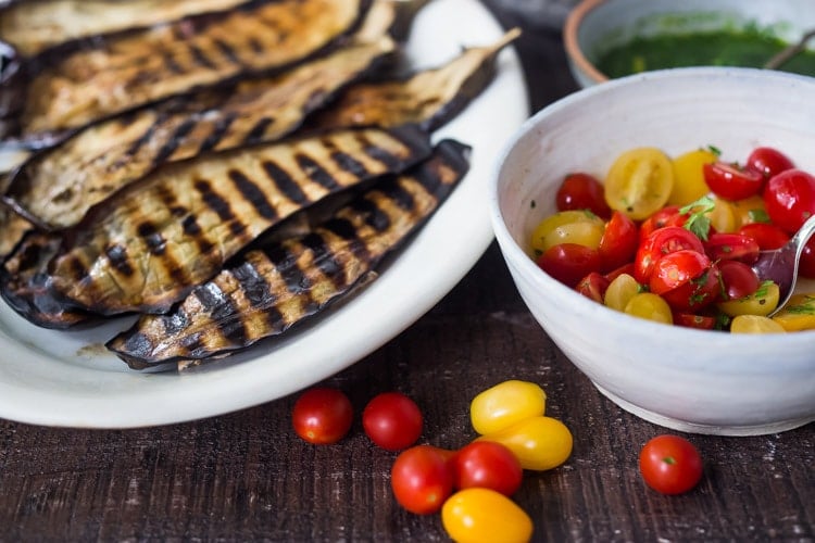 Grilled Eggplant Steaks with Fresh Tomato Relish and an Italian herb sauce called Gremolata. Keep it vegan or add crumbled cheese. A simple, healthy dinner recipe! #eggplant Feastingathome #grilledeggplant #gremolata #eggplantsteaks #eggplantrecipes #eggplantsteaks #healthydinner #meatlessdinner #vegan 