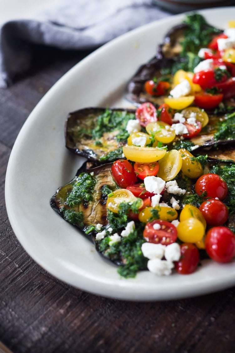 Grilled Eggplant Steaks with Fresh Tomato Relish and an Italian herb sauce called Gremolata. Keep it vegan or add crumbled cheese. A simple, healthy dinner recipe! #eggplant Feastingathome #grilledeggplant #gremolata #eggplantrecipes #eggplantsteaks #healthydinner #meatlessdinner #vegan 