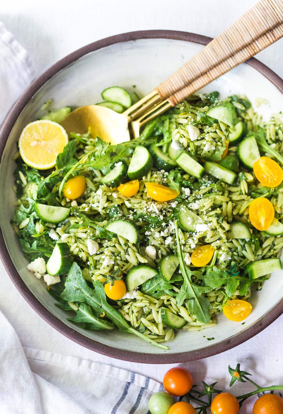 This Orzo Salad is tossed with a lemon basil dressing, with fresh cucumbers, tomatoes and arugula. A healthy, vegan, pasta salad that can be made ahead for midweek lunches or potlucks. Keep it vegan or add feta! 