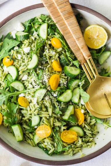 This Orzo Salad is tossed with a lemon basil dressing, with fresh cucumbers, tomatoes and arugula. A healthy, vegan, pasta salad that can be made ahead for midweek lunches or potlucks. Keep it vegan or add feta! 