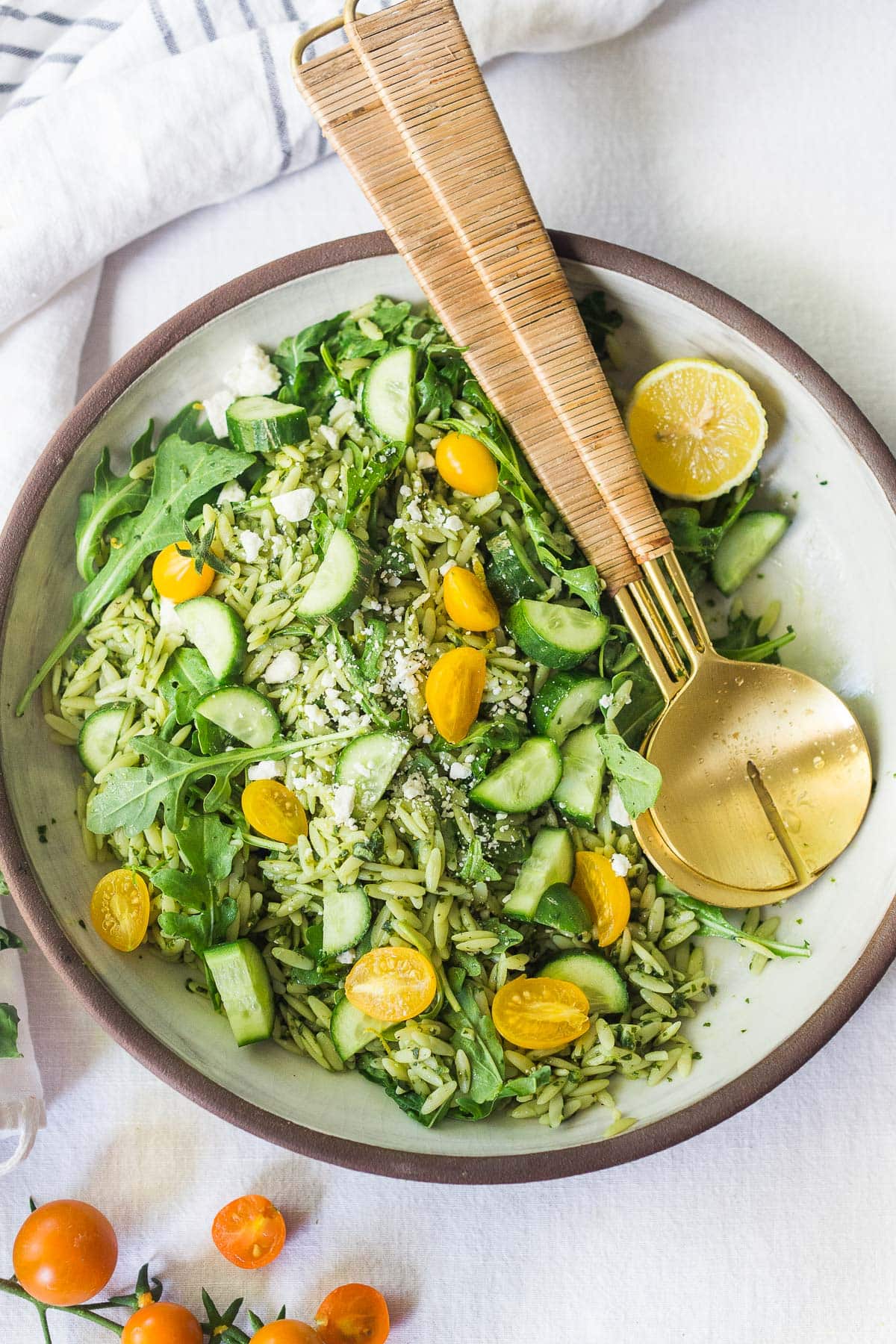 This Orzo Salad is tossed with a lemon basil dressing, with fresh cucumbers, tomatoes and arugula. A healthy, vegan, pasta salad that can be made ahead for midweek lunches or potlucks. Keep it vegan or add feta! 