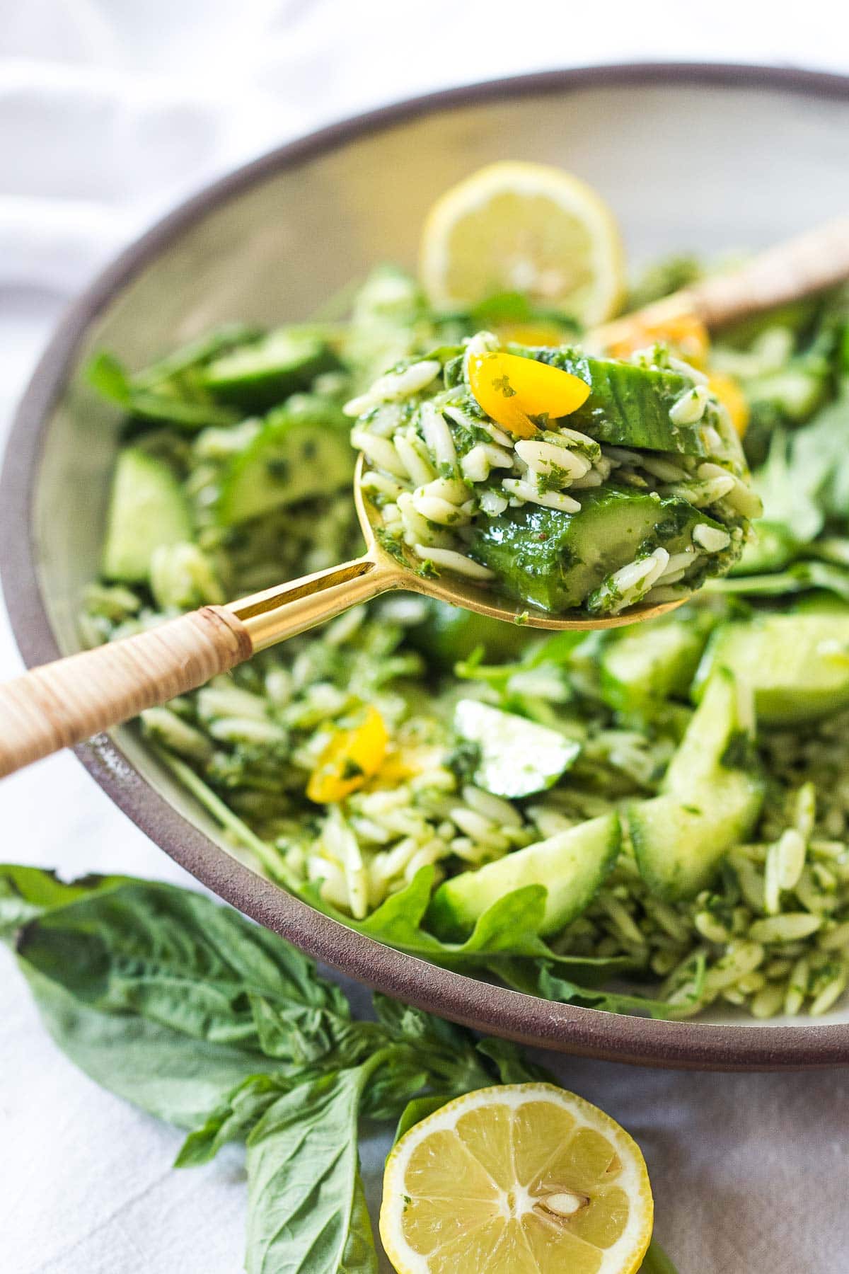 This Orzo Salad is tossed with a lemon basil dressing, with fresh cucumbers, tomatoes and arugula. A healthy, vegan, pasta salad that can be made ahead for midweek lunches or potlucks. Keep it vegan or add feta! 