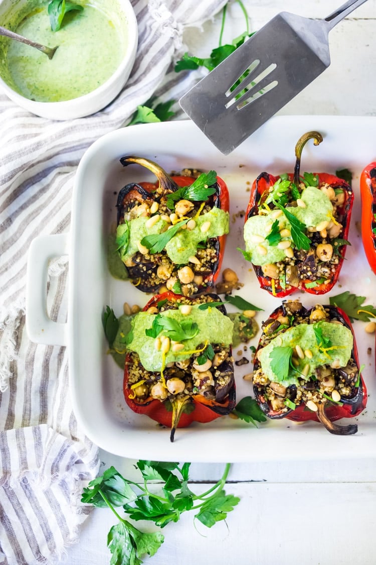 Middle Eastern Stuffed Peppers with Quinoa, Eggplant, Chickpeas and Zhoug Yogurt are the perfect make-ahead meal for summer gatherings and potlucks. Or meal prep them on Sunday to serve up during the busy workweek! Gluten-free, healthy and Vegan adaptable! #stuffedpeppers #zhoug 