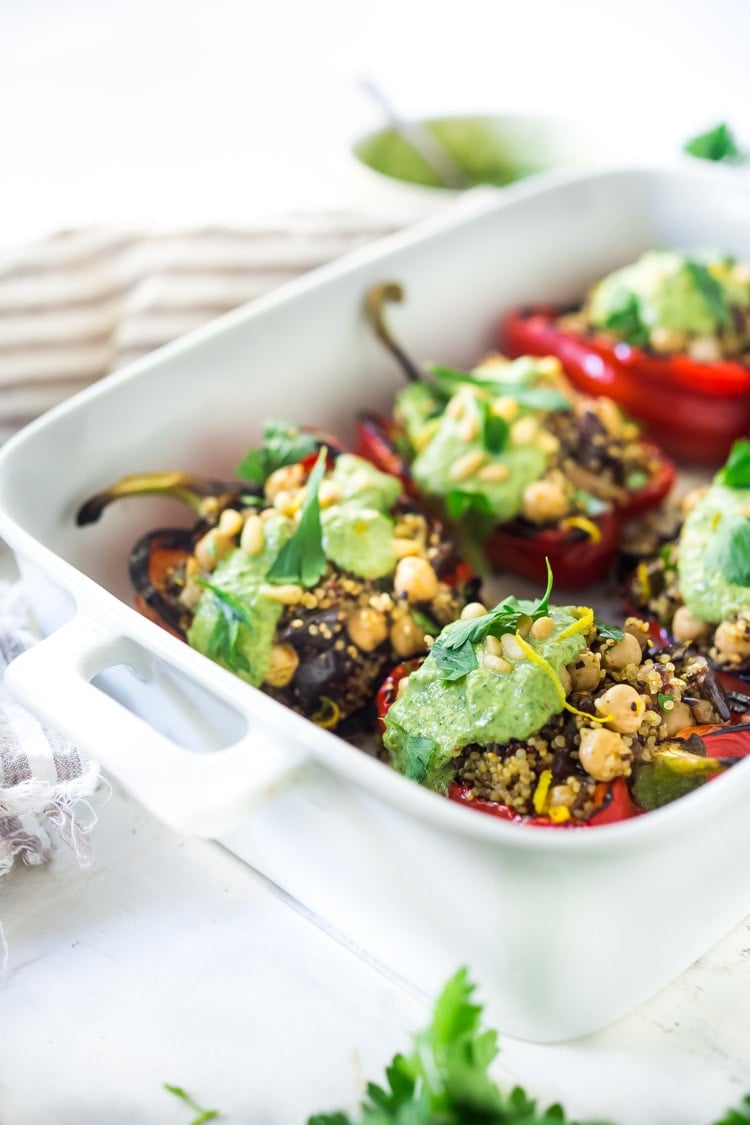 These healthy, vegetarian Stuffed Peppers with Quinoa, Eggplant, Chickpeas, Zaatar Spice and Zhoug Yogurt are the perfect make-ahead meal for summer gatherings and potlucks. Or meal prep them on Sunday to serve up during the busy workweek! Gluten free and Vegan adaptable! #stuffedpeppers | Feasting at Home 