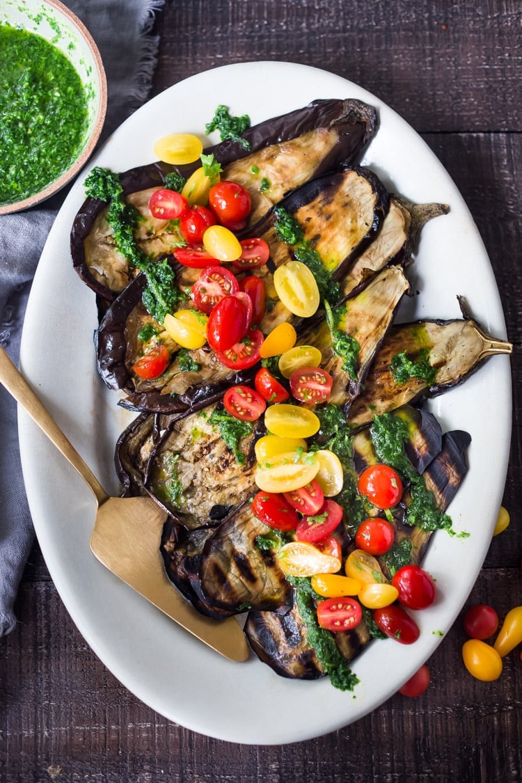 Grilled Eggplant Steaks with Fresh Tomato Relish and an Italian herb sauce called Gremolata. Keep it vegan or add crumbled cheese. A simple, healthy dinner recipe! #eggplant Feastingathome #grilledeggplant #gremolata #eggplantsteaks #eggplantrecipes #eggplantsteaks #healthydinner #meatlessdinner #vegan 