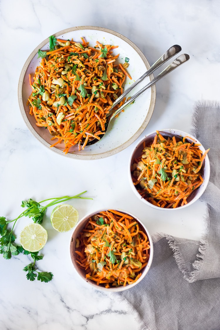 Bombay Carrot Salad with cashews and raisins, tossed in a fragrant Indian Curry dressing. Healthy and vegan this carrot salad recipe is so EASY to make, and can be made-ahead. #carrotsalad #carrotslaw #vegan #indiancarrotsalad #recipe #carrotsaladrecipe 