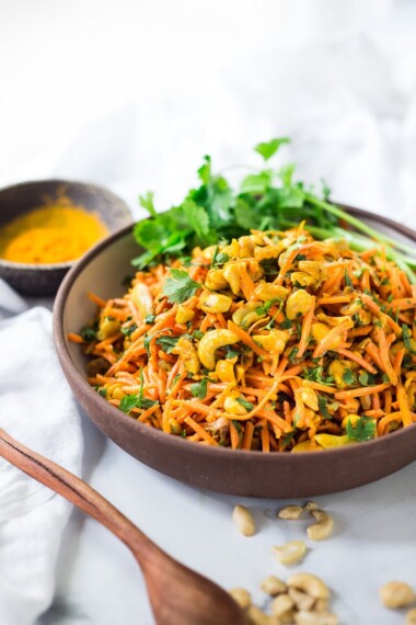 Bombay Carrot Salad with cashews and raisins, tossed in a fragrant Indian Curry dressing. Healthy and vegan this carrot salad recipe is so EASY to make, and can be made-ahead. #carrotsalad #carrotslaw #vegan #indiancarrotsalad #recipe #carrotsaladrecipe