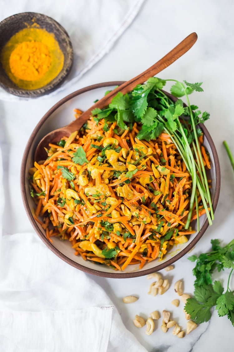 Bombay Carrot Salad with cashews and raisins, tossed in a fragrant Indian Curry dressing. Healthy and vegan this carrot salad recipe is so EASY to make, and can be made-ahead. #carrotsalad #carrotslaw #vegan #indiancarrotsalad #recipe #carrotsaladrecipe 
