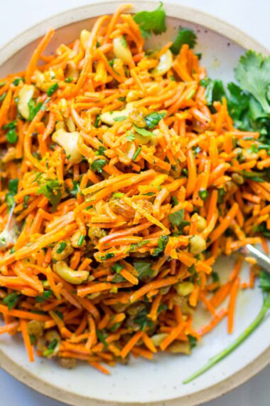 Fresh and flavorful, this carrot salad recipe is infused with Indian flavor! Studded with toasted cashews and raisins, fresh grated carrots are tossed in a delicious Indian curry dressing. Easy, healthy, vegan, and perfect for gatherings!