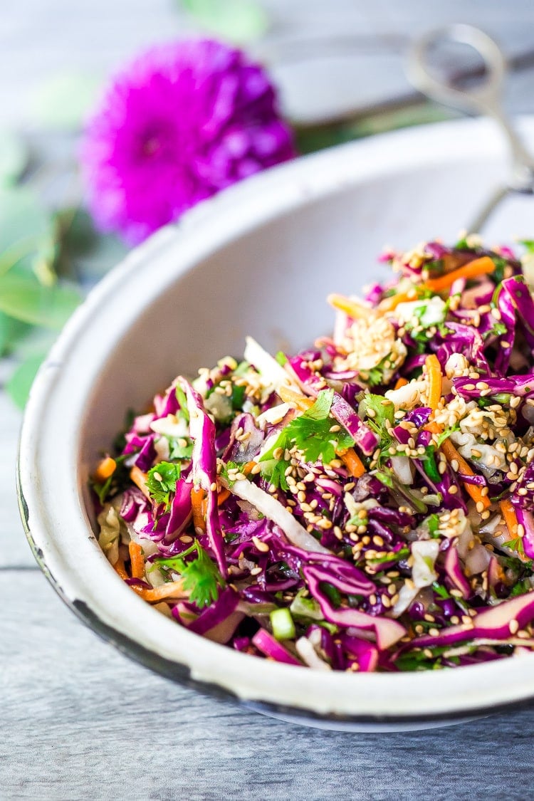 Easy Crunchy Asian Slaw- a simple vegan slaw with the BEST SLAW DRESSING EVER that can be made ahead! Serve this alongside fish, tofu, or chicken or stuffed into tacos, topped onto burgers, or added to buddha bowls. A great way to add more veggies into your everyday meals. #slaw #asianslaw #veganslaw #easyslaw #tacoslaw