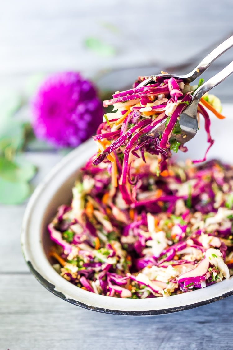 Easy Crunchy Asian Slaw- a simple vegan slaw with the BEST SLAW DRESSING EVER that can be made ahead! Serve this alongside fish, tofu, or chicken or stuffed into tacos, topped onto burgers, or added to buddha bowls. A great way to add more veggies into your everyday meals. #slaw #asianslaw #veganslaw #easyslaw #tacoslaw