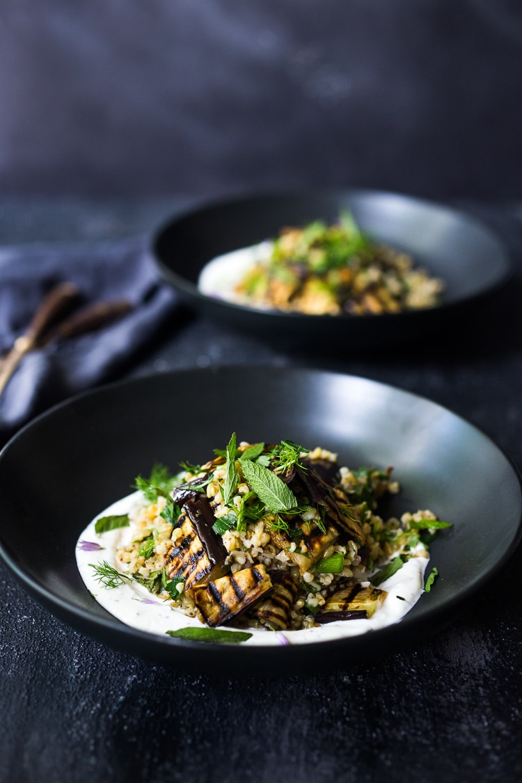 Grilled Eggplant Salad with Freekeh. Loaded up with fresh herbs and served over a tangy yogurt dressing, this healthy salad is full of Middle Eastern flavor. Vegan adaptable #freekah #eggplantsalad #freekehsalad #freekehrecipe #vegetarian #vegan #healthysalad 
