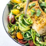 A simple, healthy Halibut recipe served over Lemony Zucchini Noodles with olive oil, garlic and parsley, topped with sweet summer tomatoes. A quick and easy low-carb meal! #keto #zucchininoodles #zoodles #halibut #halibutrecipes #lowcarb #healthy
