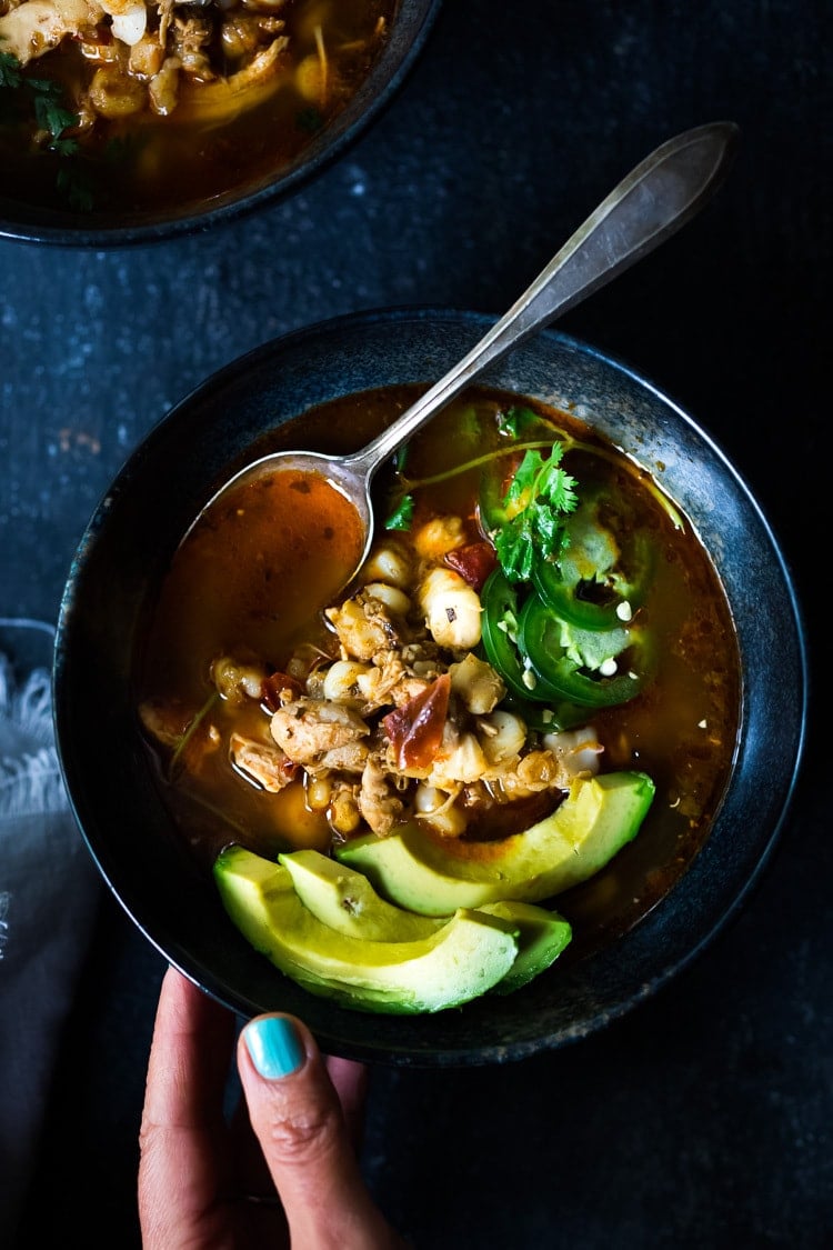 pozole rojo in a bowl with avocado