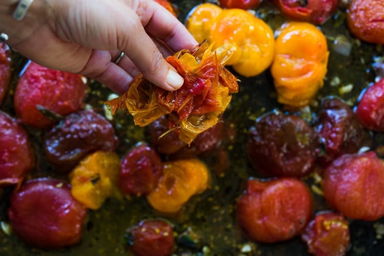 Pulling skins off of tomatoes on a sheet pan.