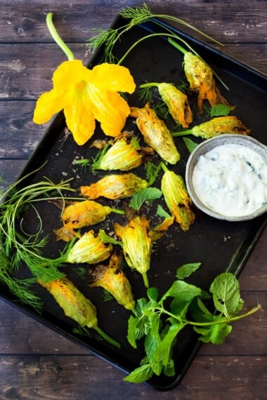 Baked Stuffed Squash Blossoms (Dolmas Style!)with ground lamb, basmati rice and fragrant Middle Eastern spices- a simple delicious main course or appetizer, inspired by the season! #dolmas #squashblossom #zucchiniblossom #squashblossoms #stuffedsquashblossom #baked #keto #paleo #lamb #lambrecipes #groundlamb