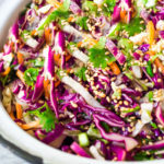 Easy Crunchy Asian Slaw- a simple vegan slaw with the BEST SLAW DRESSING EVER that can be made ahead! Serve this alongside fish, tofu, or chicken or stuffed into tacos, topped onto burgers, or added to buddha bowls. A great way to add more veggies into your everyday meals. #slaw #asianslaw #veganslaw #easyslaw #tacoslaw