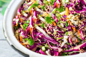 Easy Crunchy Asian Slaw- a simple vegan slaw with the BEST SLAW DRESSING EVER that can be made ahead! Serve this alongside fish, tofu, or chicken or stuffed into tacos, topped onto burgers, or added to buddha bowls. A great way to add more veggies into your everyday meals. #slaw #asianslaw #veganslaw #easyslaw #tacoslaw