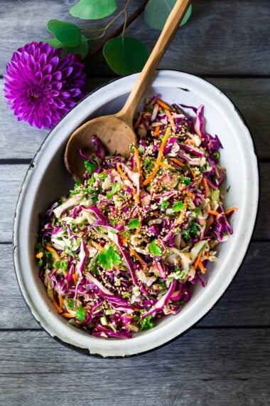 Easy Crunchy Asian Slaw- a simple vegan slaw with the BEST SLAW DRESSING EVER that can be made ahead! Serve this alongside fish, tofu, or chicken or stuffed into tacos, topped onto burgers, or added to buddha bowls. A great way to add more veggies into your everyday meals. #slaw #asianslaw #veganslaw #easyslaw #tacoslaw