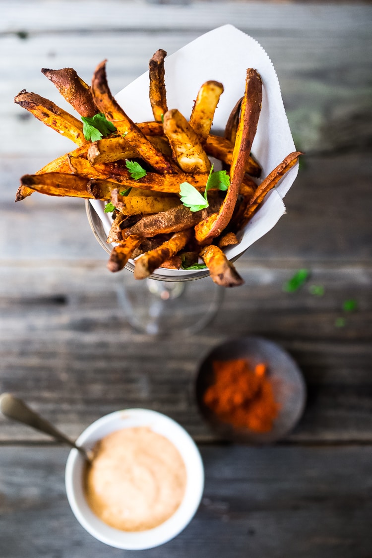 Crispy Baked Sweet Potato Fries - Healthy,  EASY and oh so crispy! A delicious vegan side that is good for you and full of amazing flavor!  Vegan and Gluten-free. #sweetpotato #sweetpotatofries #baked #vegan #bakedsweetpotato #harissa