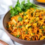 This Carrot Raisin Salad is studded with cashews and tossed in the most flavorful Indian curry dressing.  Simple to make, healthy vegan, this carrot salad recipe is so addicting! 