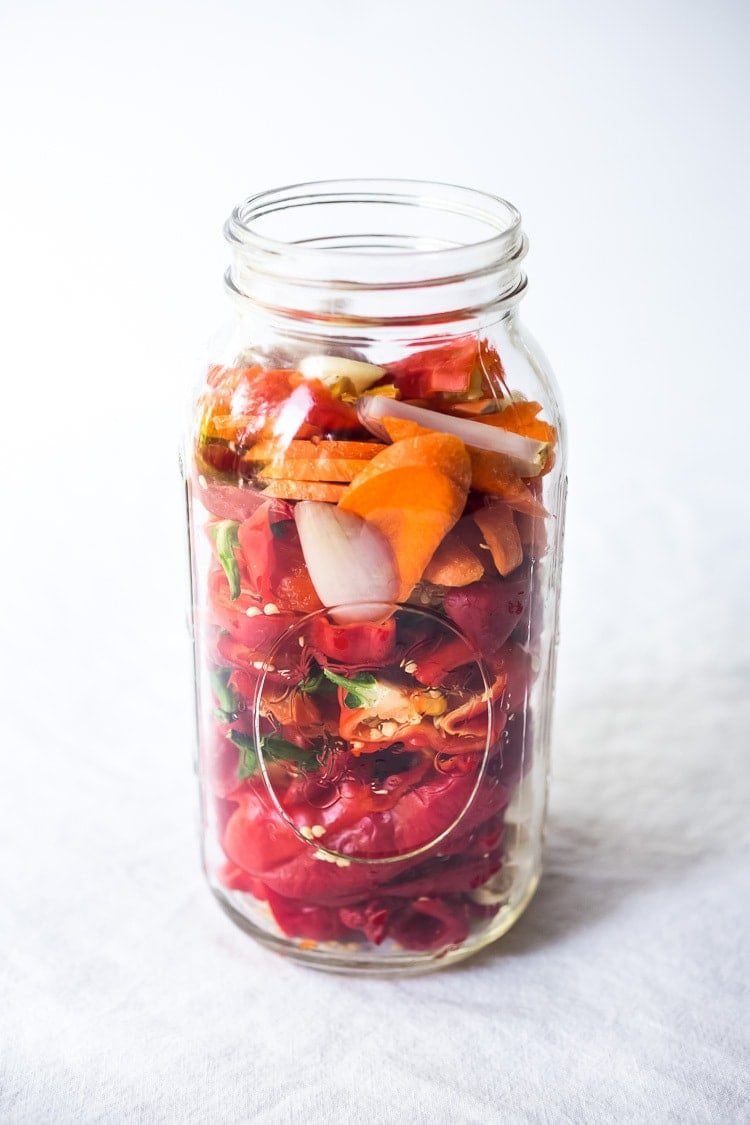 layering the veggies and chilies in the mason jar. 