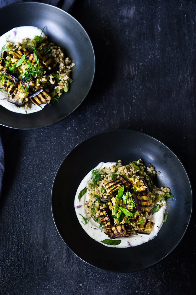 Grilled Eggplant Salad with Freekeh. Loaded up with fresh herbs and served over a tangy yogurt dressing, this healthy salad is full of Middle Eastern flavor. Vegan adaptable #freekah #eggplantsalad #freekehsalad #freekehrecipe #vegetarian #vegan #healthysalad 