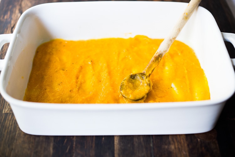 butternut sauce being spread onthe baking dish.
