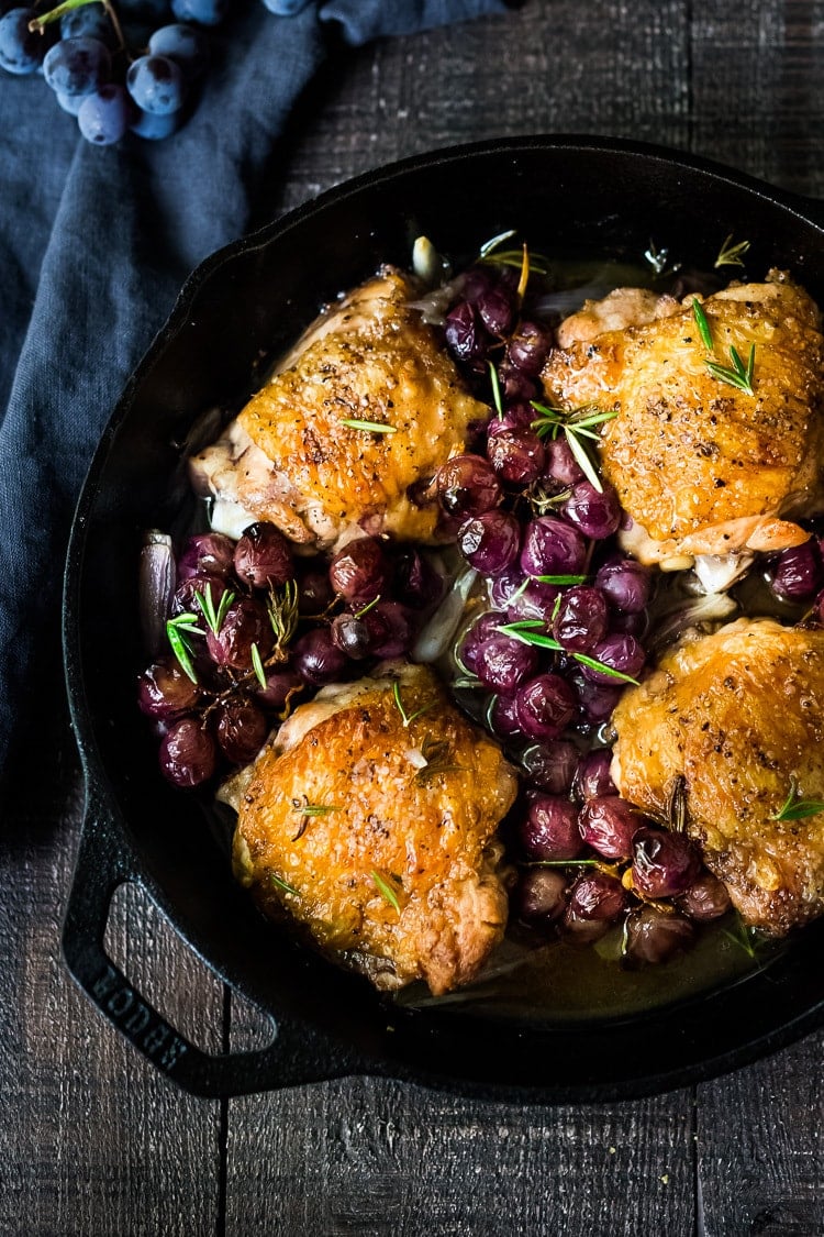 Rosemary Chicken Thighs with Roasted Grapes and Shallots, served over Whipped Ginger Sweet Potatoes - a simple, easy, fall-inspired skillet dinner that can be made in 30 minutes!  #rosemarychicken #skilletchicken #bakedchicken #roastedgrapes #chicken #chickenthighs 