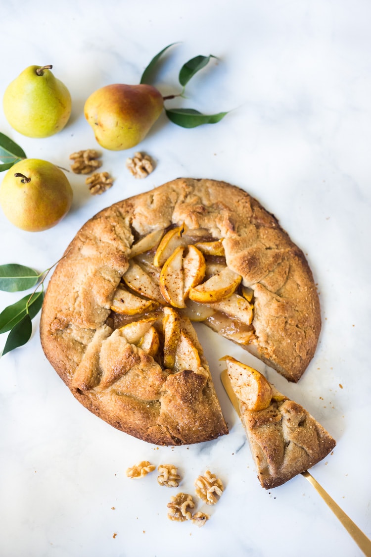 rustic pear galette with spatula removing slice.