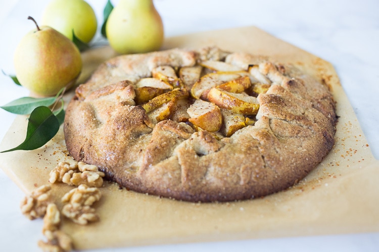 baked, golden, and crispy pear galette sprinkled with spices, cooling on parchment paper.