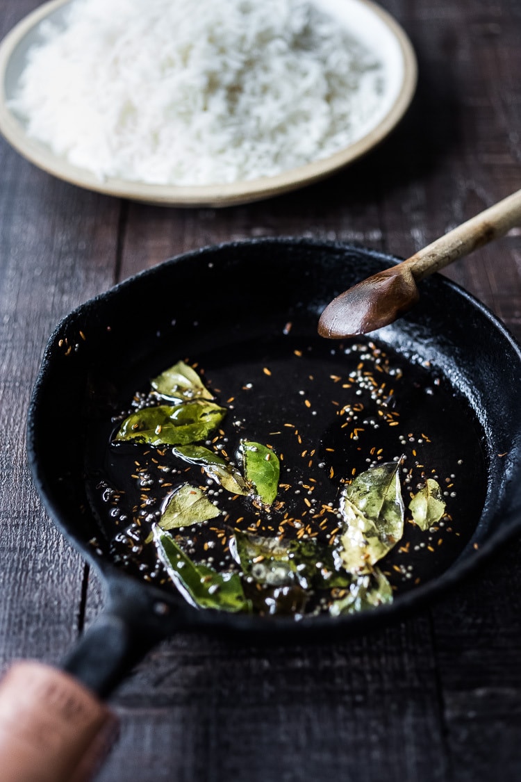 Tempering oil with curry leaves, cumin seeds, mustard seeds and fennel seeds