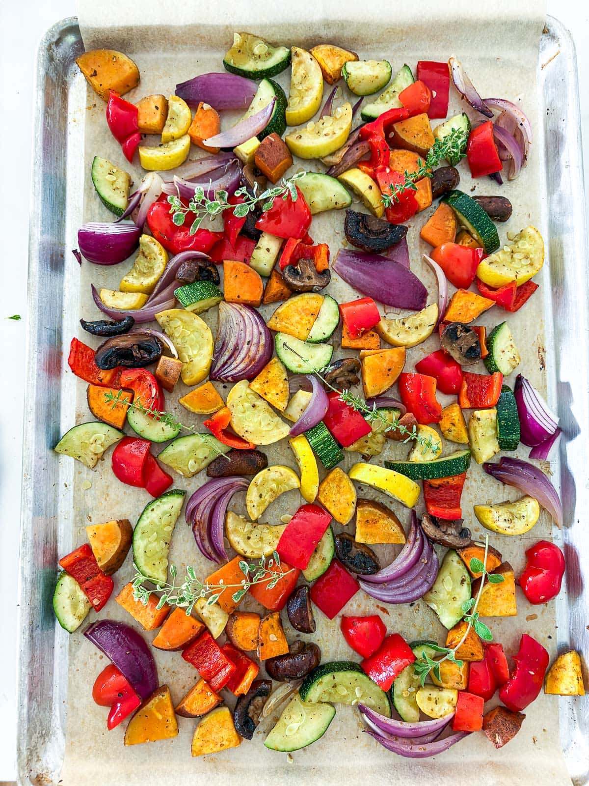 Placing the veggies on a parchment lined sheet pan. 