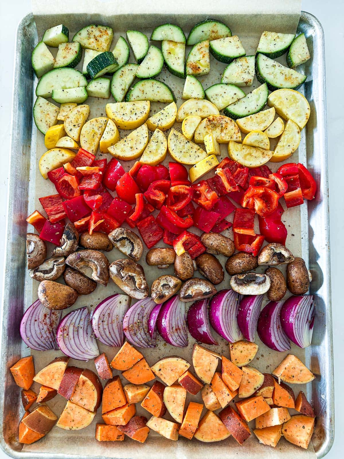 Option showing the veggies on a parchment lined sheet pan but in separate rows. 